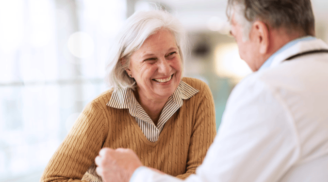 Imagem de uma senhora conversando com um médico
